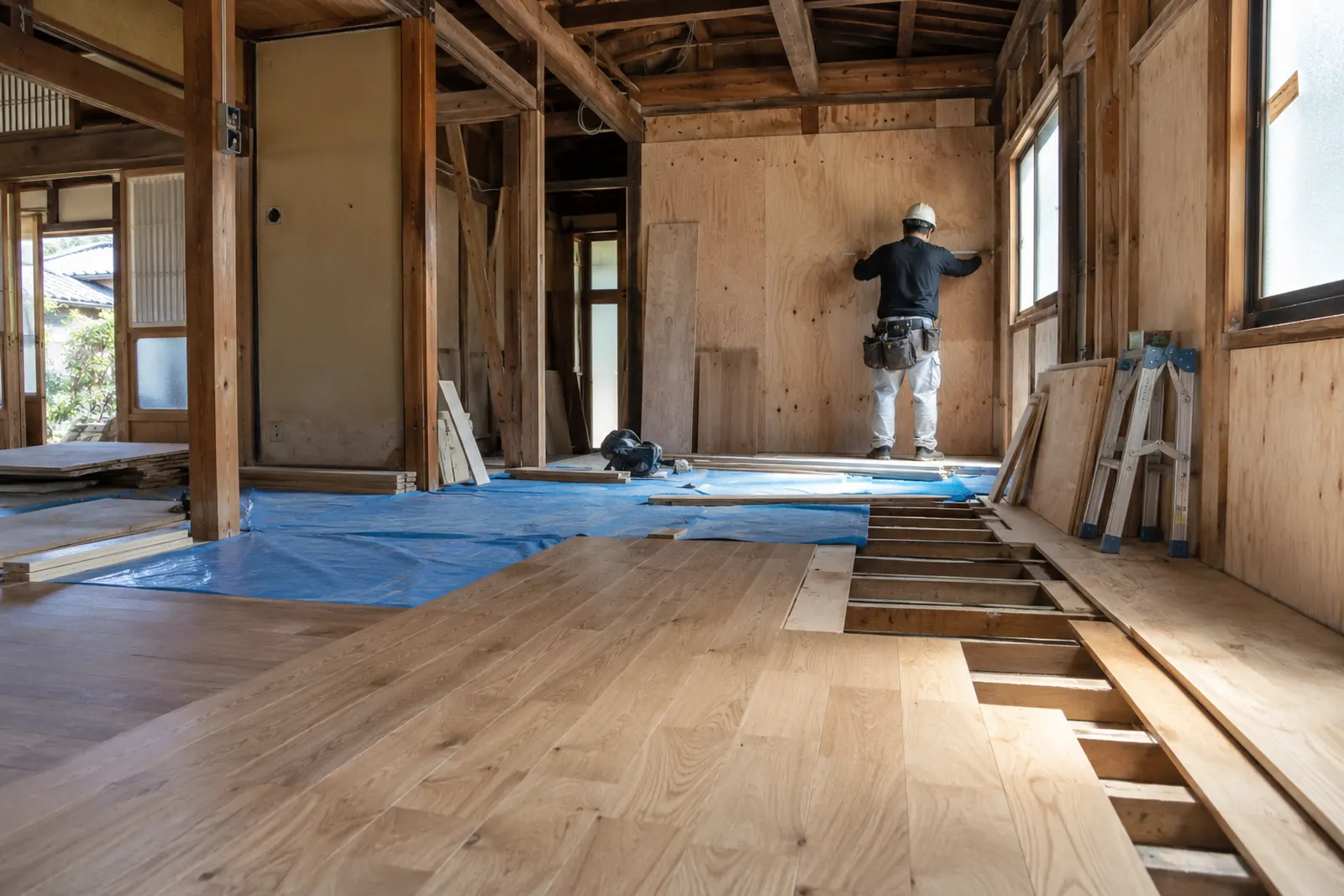 リフォーム中の木造住宅で、壁を確かめる大工