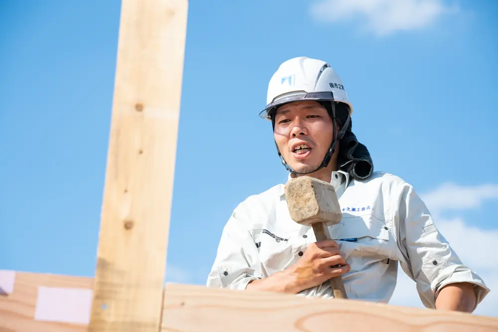 木槌を手に、現場で話す市之瀬工務店の大工